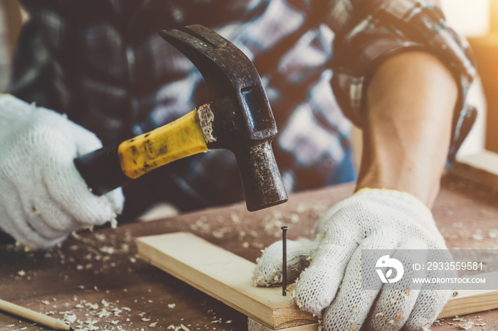 Carpenter working on wood craft at workshop to produce construction material or wooden furniture. The young Asian carpenter use professional tools for crafting. DIY maker and carpentry work concept.