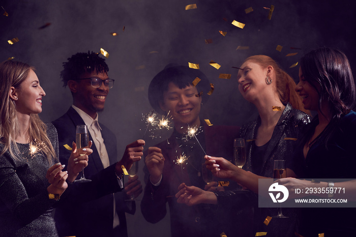 Multi-ethnic group of elegant people enjoying Christmas party in smoky night club with glitter falling overhead, copy space