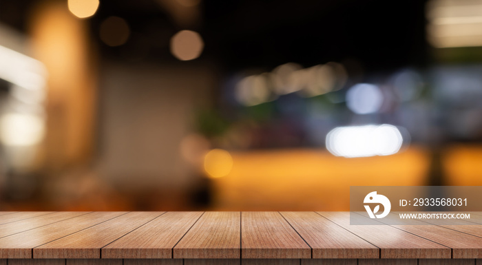 Empty wooden table top with lights bokeh on blur restaurant background.