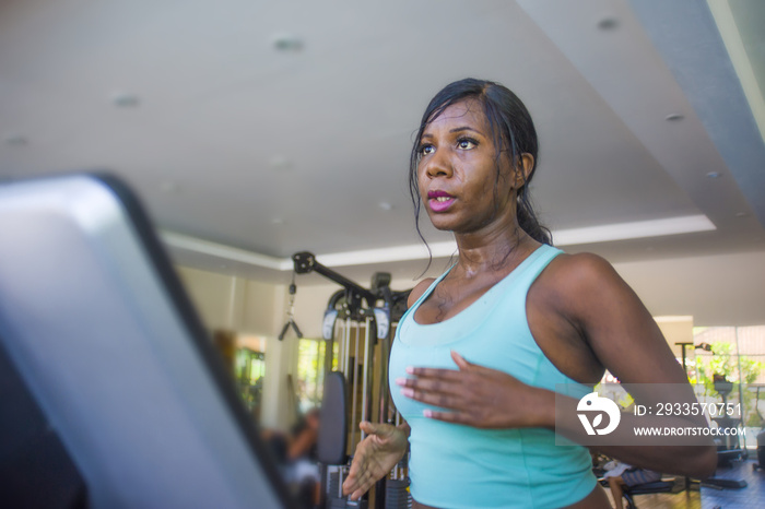 indoors gym portrait of young attractive black afro American woman training hard all sweaty at fitness club a treadmill running workout in body care