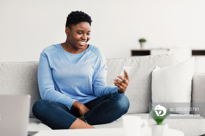 Smiling black woman using mobile phone for videocall