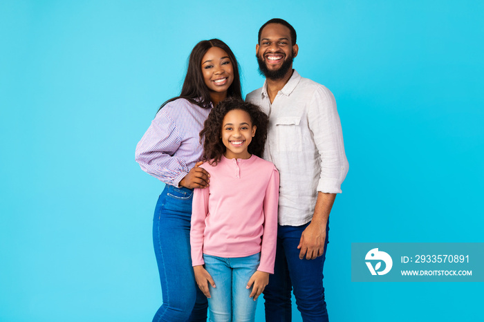 African American man posing with wife and smiling daughter