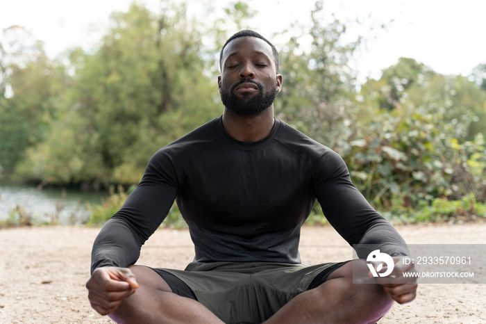 Athletic man meditating in park