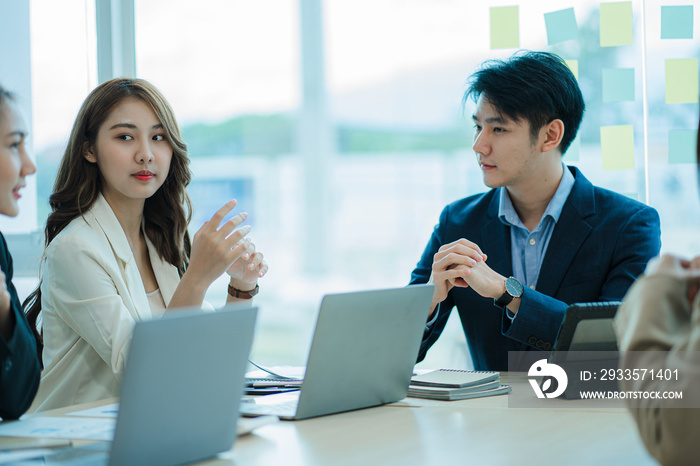 Young men and women of the new generation of entrepreneurs. Presenting a project for the satisfaction of Asian female employees Collaborate in a creative workplace in the office.