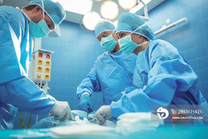 Team of surgeons performing operation in operation theater