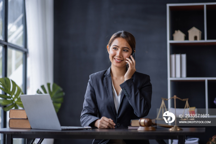 Attractive lawyer in office Business woman and lawyers discussing contract papers with brass scale on wooden desk in workplace. Law, legal services, advice, Justice and real estate concept.