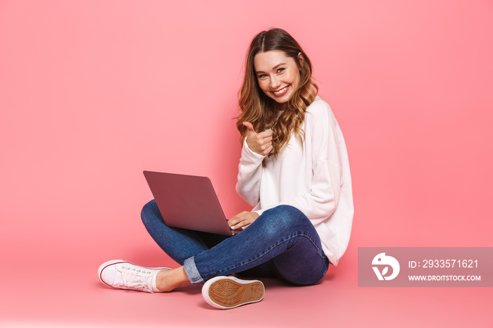 Portrait of a smiling young woman sitting with legs crossed