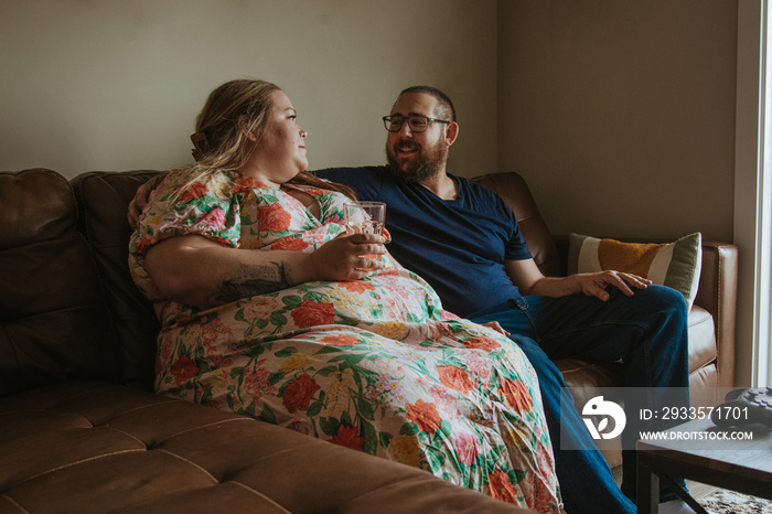 couple sits on sofa chatting