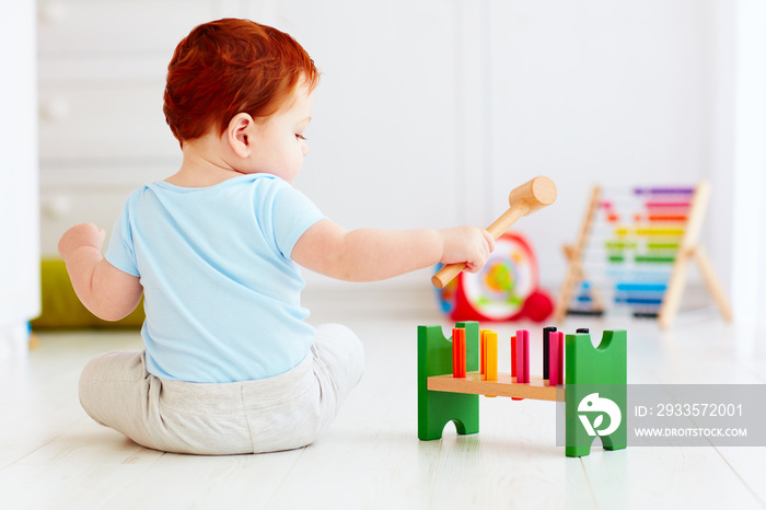 cute infant baby playing with wooden hammer block toy