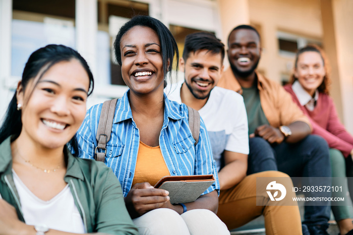 Multi-ethnic group of happy college students enjoy outdoors and look at camera.