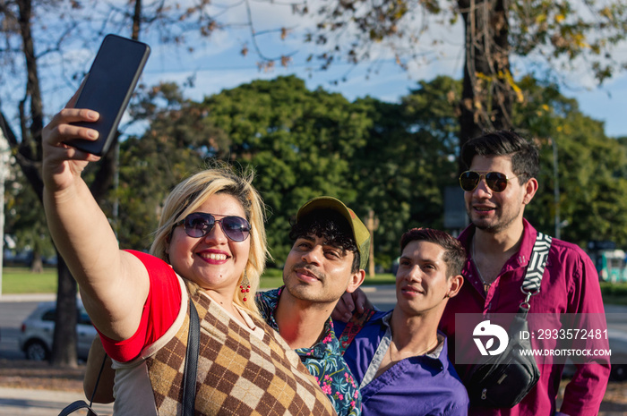 diverse group of friend outdoors standing taking selfie with phone