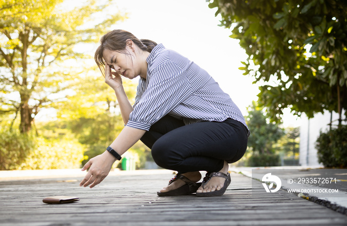 Exhausted asian woman suffer from headache,migraine,tired female people having vertigo,feel dizzy,fatigue,fainted while stooping down,reached towards her wallet that had fallen on floor,health care