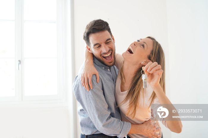 Happy couple celebrating with keys to new home