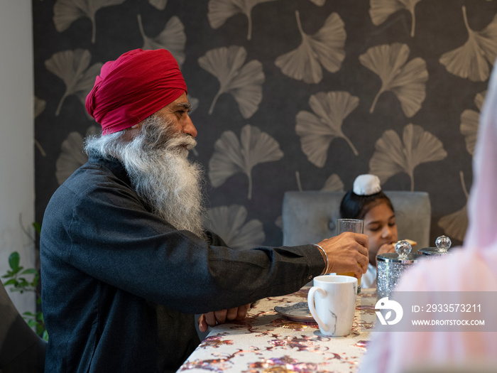 Grandfather and grandson (6-7) eating meal at home