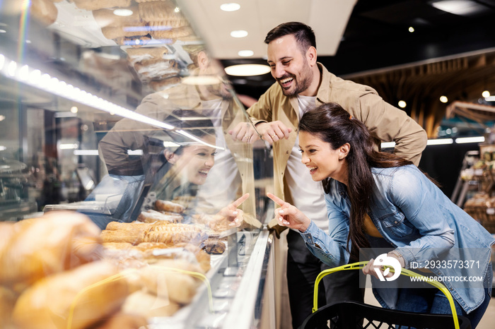 A happy couple choosing pastry supermarket.