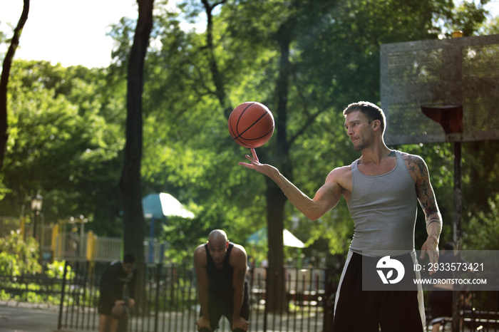 Man looking at friend balancing basketball on finger