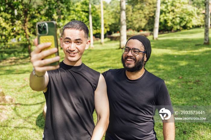 Friends taking photos of each other in the park after a workout