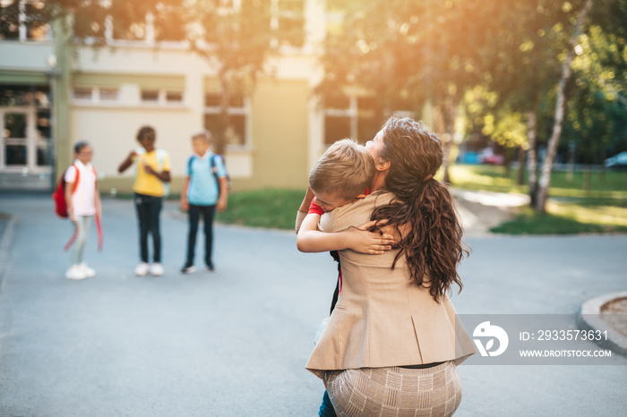 First day at school. Mother leads her little child, school boyl, in first grade.