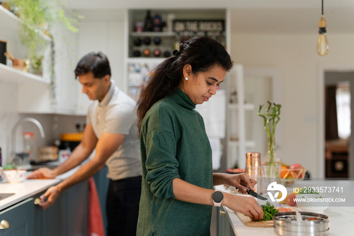 Woman and man preparing food in kitchen