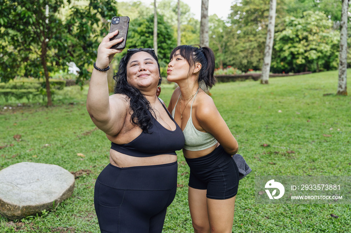 Friends taking photos of each other in the park after a workout