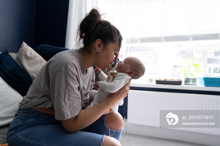 Mother carrying newborn baby girl at home