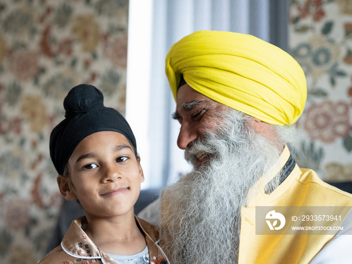 Smiling grandfather and grandson (6-7) in traditional clothing