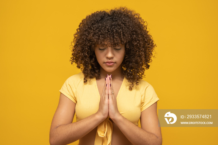 Smiling peaceful young woman practicing yoga and meditation. Calm woman making Namaste gesture and looking at camera. Yoga concept. Gratitude.