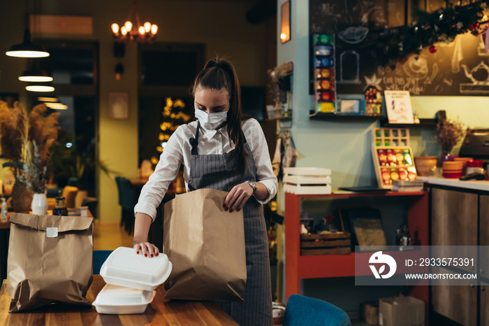 woman waitress preparing take away food in restaurant