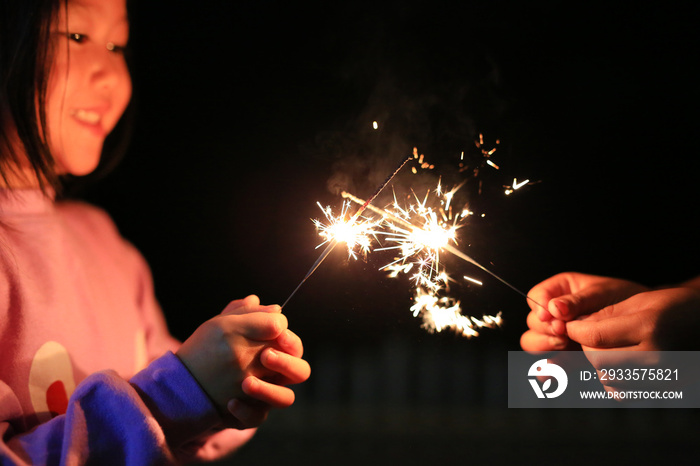 Little Asian child girl enjoy playing firecrackers.