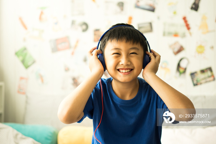 Kid listening to music on bed in bedroom