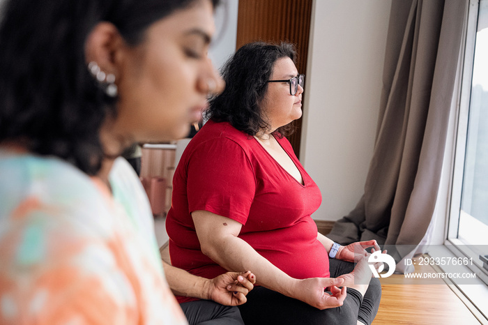 Group of friends meditating and doing yoga at home