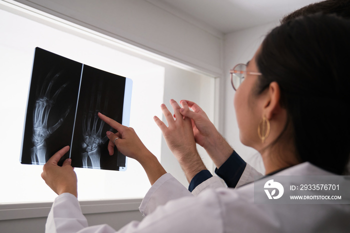 Two doctor examining hand x-ray image. Rheumatoid arthritis.