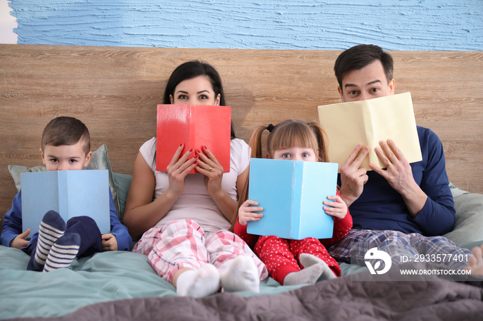 Happy family reading books in bed