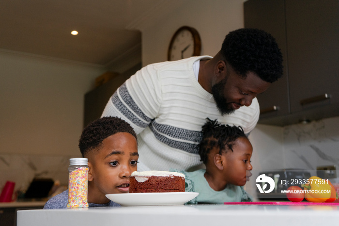 Father and children (2-3, 6-7) looking at food on table