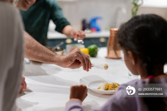 Father serving meal to daughter