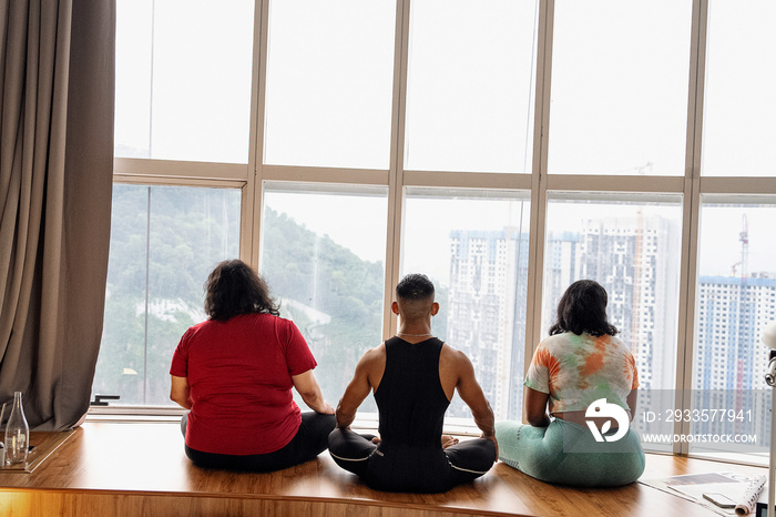 Group of friends meditating and doing yoga at home