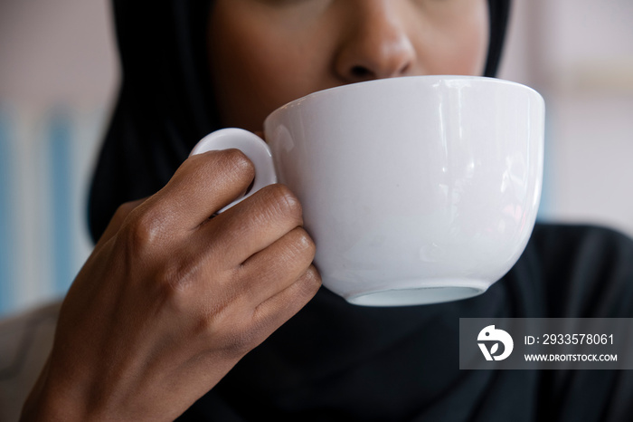 Close-up of young woman drinking coffee