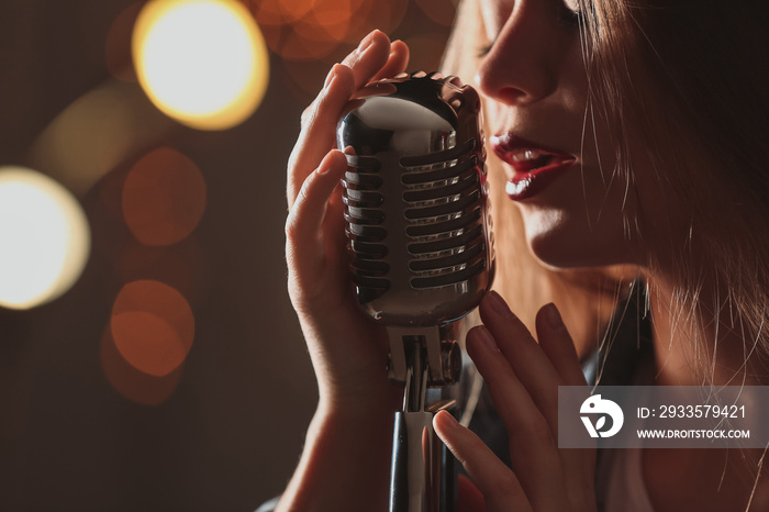 Beautiful female singer with microphone on stage, closeup