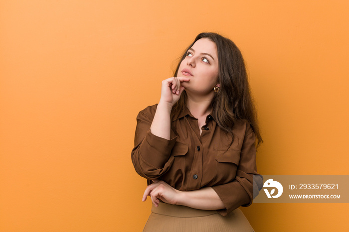 Young curvy russian woman looking sideways with doubtful and skeptical expression.