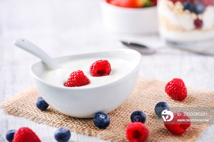 yogurt with forest fruits in white porcelain bowl. Yogurt with raspberries and blueberries.