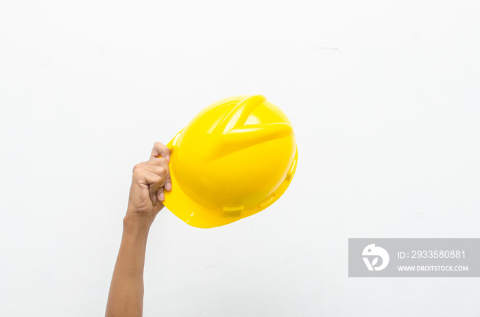 Male hand holding yellow safey hard hat isolated over white background. work safety concept. labour day concept.