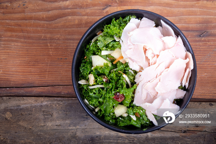 Healthy bowl of kale salad with turkey breast protein