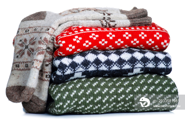 Stack folded knitted sweaters, socks Christmas on white background isolation