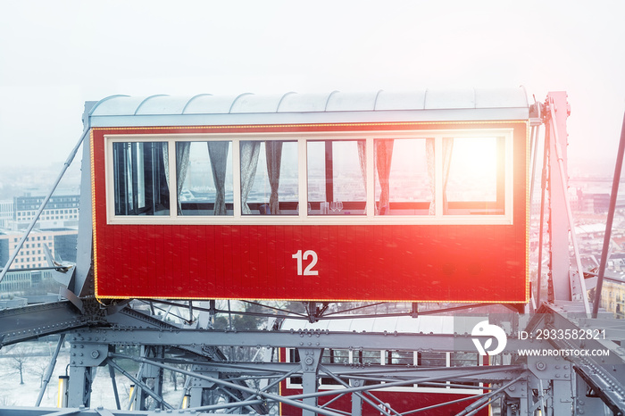 aerial red cabin of cafe or restaurant served for birthday party celebration or romantic dinner on oldest ferris wheel in Vienna Prater amusement fair park. Bright sunset or sunrise sun through window