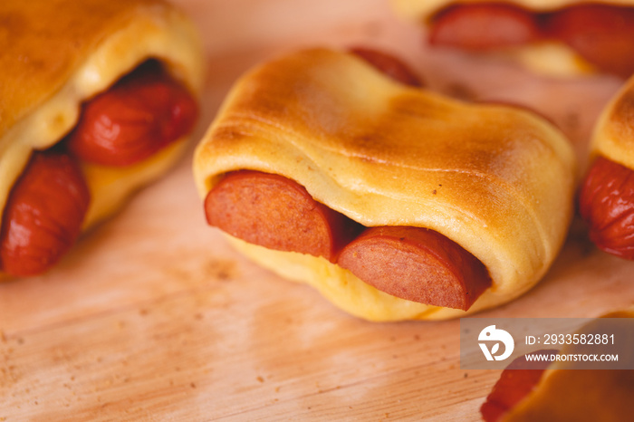 Cachorro-quente assado com massa de pão (hot dog sírio) ou enroladinho de salsicha na massa de pão. Salgado tradicional no Brasil. Comida brasileira. Cachorro quente.