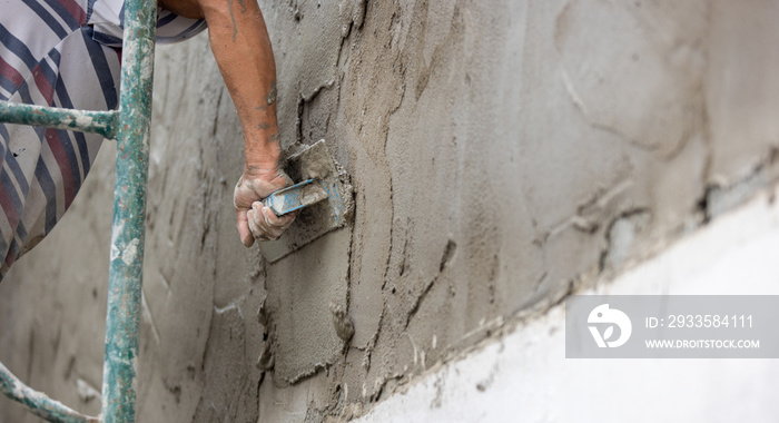 Unsafe construction of Myanmar migrant workers while plastering a wall in construction site , Thailand.