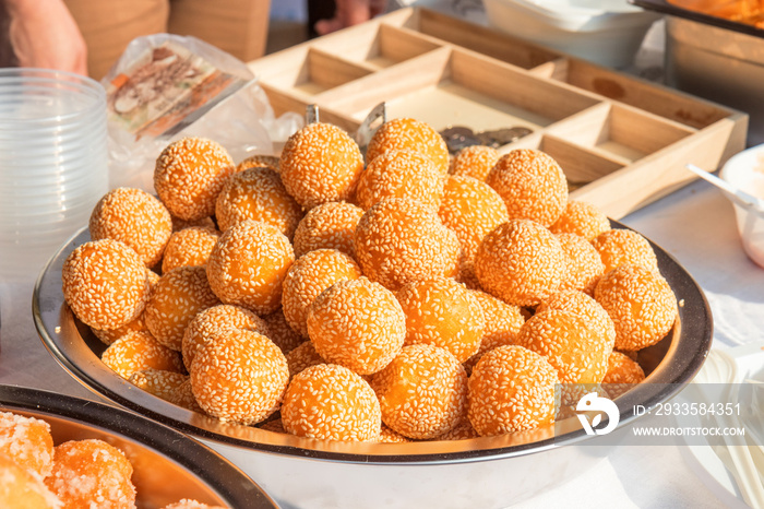 a bunch of sesame balls served on a metal bowl on a farm street market