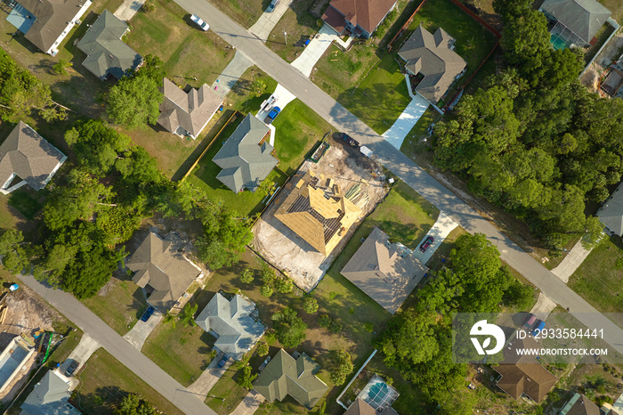 Aerial view of suburban private house wit wooden roof frame under construction in Florida quiet rural area