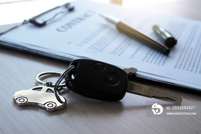 Car keys placed on contract documents about car loans.