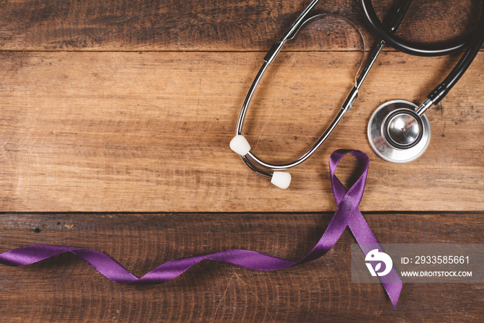 Purple ribbon and stethoscope on a wooden table. Concept of EPILEPSY awareness and medical treatment